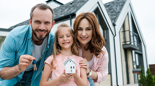 Parent and daughter holding miniature house and key photo